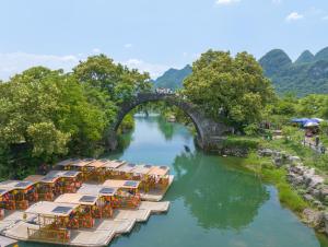 a bridge over a river with a bunch of tables at Yangshuo Yi ju hotel in Yangshuo