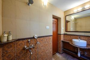 een badkamer met een wastafel en een spiegel bij Neemrana's Three Waters in Betul +39 foto's