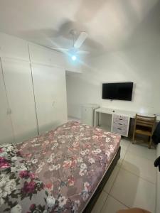 a bedroom with a bed and a flat screen tv at Hostel San Pietro in Santos