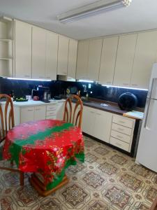 a kitchen with a table and chairs with a red table cloth at Hostel San Pietro in Santos
