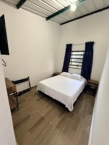 a bedroom with a white bed and a window at Villa Esther - Finca campestre en Mesitas del Colegio in El Colegio