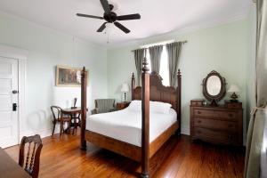 a bedroom with a bed and a ceiling fan at Heights Ironworks Bed & Breakfast in Houston +4 photos