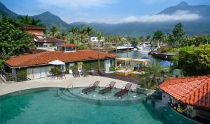 a large swimming pool with two chairs in a resort at Angra Boutique Hotel in Angra dos Reis