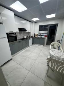 een keuken met witte apparatuur en een tafel en stoelen bij Grands appartement 3 chambres à résidence Valmascort, Annaba in Annaba