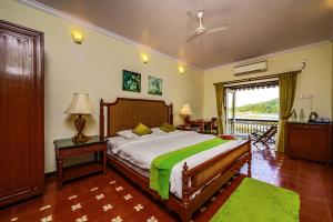 een slaapkamer met een groot bed en een balkon bij Neemrana's Three Waters in Betul