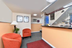 une salle d'attente avec une chaise et un comptoir dans l'établissement Media Inn & Suites, à Media