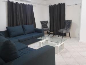 een woonkamer met een bank en een glazen tafel bij The Nexus Suites in Gaborone +2 foto's