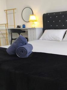 a bedroom with a bed with a black blanket and a desk at Inap kluster Alamanda in Kuala Kangsar