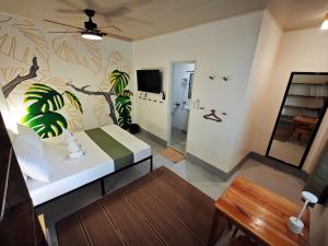 ein Schlafzimmer mit einem Bett mit einem Pflanzenwandbild an der Wand in der Unterkunft Gubat Apartelle in Lalao