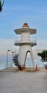 een vuurtoren op een strand met de oceaan op de achtergrond bij Three Monkeys Mae Nam beach in Nathon Bay