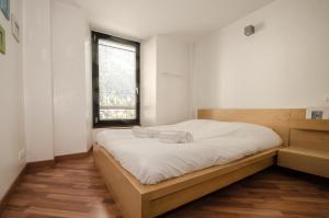 1 dormitorio con 1 cama con sábanas blancas y ventana en Cocoon, en Chamonix-Mont-Blanc