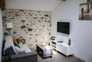a living room with a couch and a tv at Refuge de Deux Pins in La Forêt-sur-Sèvre