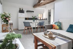 ein Wohnzimmer mit Sofa und Tisch in der Unterkunft Gîte in La Forêt-sur-Sèvre + 5 Fotos