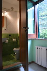 a bathroom with a toilet and a sink and a window at La Sorgente B&B in Cetara