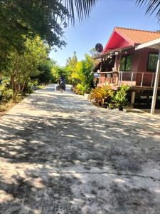 een persoon die langs een gebouw op straat loopt bij Green moon Home stay 51 in Buriram