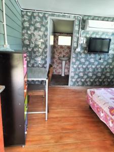 een kamer met een tafel en een bed en een televisie bij Green moon Home stay 51 in Buriram
