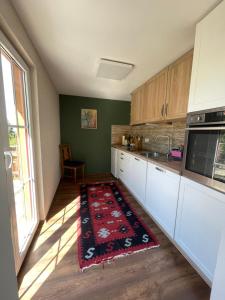een keuken met witte kasten en een rood tapijt op de vloer bij Lebensfreude in Niederdorla +6 foto's