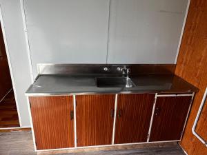 a kitchen with a sink and wooden cabinets at Mount Prime Private Suite in Mount Maunganui