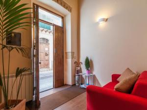 a living room with a red couch and a sliding glass door at Il Borgo House in Cagliari