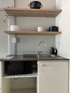 a kitchen counter with a sink and a microwave at Studio in Woodstock in Cape Town +9 photos
