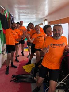 a group of people in orange shirts posing for a picture at Alma Maldiva, Beach Hotel in Ariyaddu