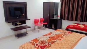 Un dormitorio con una cama y dos sillas rojas. en Hotel d c vilas, en Agra