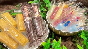 dois recipientes de plástico cheios de diferentes tipos de doces em 天然温泉 越前の湯 御宿野乃福井 em Fukui