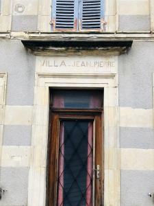een gebouw met een deur met een bord erboven bij Villa Jean Pierre in Pougues-les-Eaux