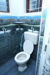 a bathroom with a toilet and a mural of swans at Sparrow valley in Coonoor +33 photos