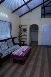 a living room with a couch and a table at Sparrow valley in Coonoor
