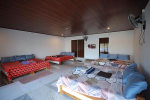 a room with two beds and a couch in it at Coorg Backwaters in Suntikoppa