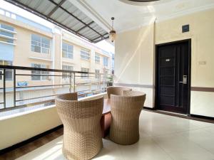 a balcony with two chairs and a window at Lily Guest House Syariah RedPartner in Bunul