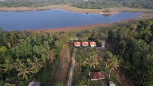 an aerial view of a house next to a lake at Coorg Backwaters in Suntikoppa