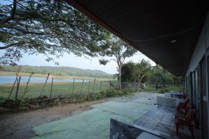a porch of a house with a view of the water at Coorg Backwaters in Suntikoppa +17 photos