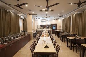 comedor con mesas, sillas y techos en Hotel New Sagar Priya, en Digha