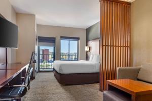 a hotel room with a bed and a balcony at Comfort Suites Florence - Cincinnati South in Florence
