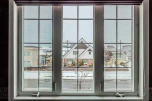 美瑛町Biei Terrace 2F 専用玄関 127平米 85型スマートTV -駅前通り&景観条例地区-的享有城市美景的开放式窗户。