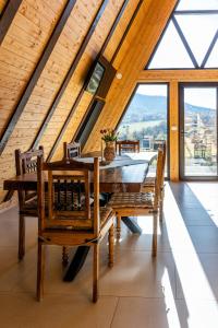 una sala da pranzo con un tavolo e alcune finestre di Dream Cottage A-Frame a Şinca Nouă