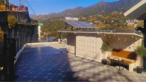 a building with a solar roof with a bench on it at Bhimtal Lakeview Cottage in Bhīm Tāl