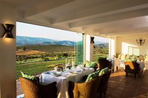 een eetkamer met een tafel en een groot raam bij Galenia Estate in Montagu