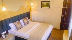 a bedroom with a large bed with a wooden headboard at Bhimtal Lakeview Cottage in Bhīm Tāl