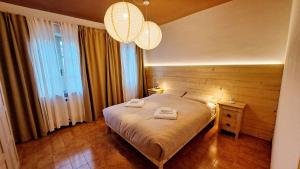 a bedroom with a bed with two towels on it at Da Nonna Isa - Ampio appartamento tra Bormio e Bernina Express in Grosotto
