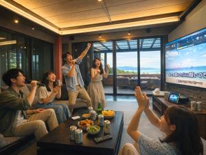 a group of people sitting in a living room watching a movie at 海の宿mare in Hakui
