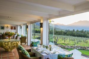 a dining room with a table and views of a vineyard at Galenia Estate in Montagu