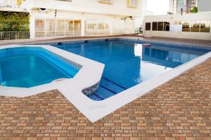 a large swimming pool with a brick floor at Fursan Apartment in Manama