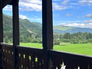 a view from a balcony of a green field and mountains at Charming Guesthouse farm in Hølera +10 photos