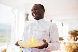 a chef holding a tray of orange juice at Galenia Estate in Montagu