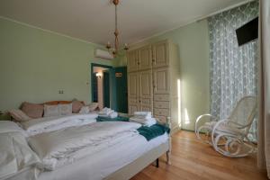 een slaapkamer met een bed met witte lakens en een stoel bij La Casetta di Renzo e Lucia in Olginate +16 foto's