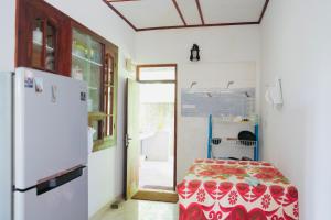 a room with a bed and a refrigerator at Romaclan Villa in Midigama East