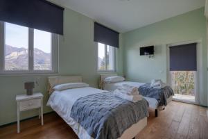 twee bedden in een kamer met twee ramen bij La Casetta di Renzo e Lucia in Olginate
